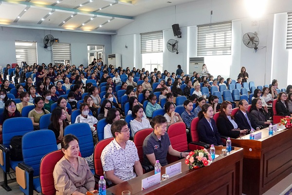 A group of people sitting in a lecture hallDescription automatically generated